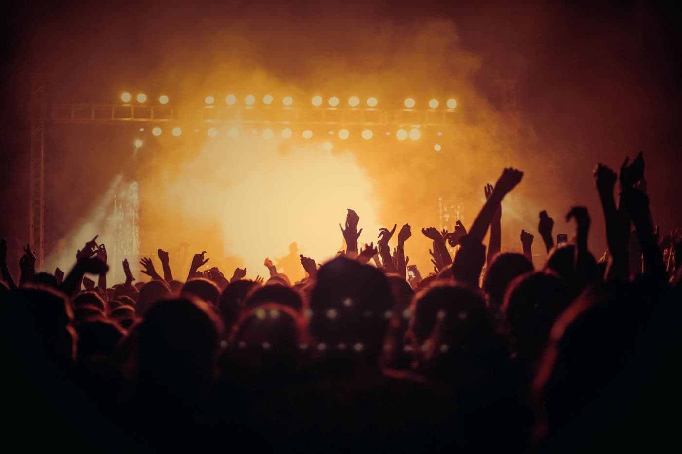 Festival crowd with raised hands in front of a stage
